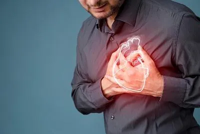A man clutching his chest in pain with a glowing white heart outline superimposed over his torso.
