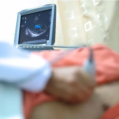 A medical professional performing an ultrasound or echocardiogram on a patient.